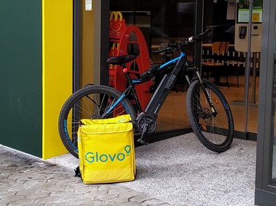 Bicicleta con la mochila de Glovo en un establecimiento de comida rápida